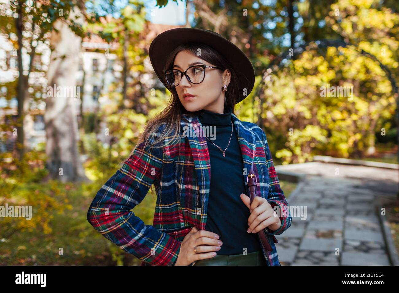 Donna che regge elegante borsa borgogna e indossa abiti autunnali nel  parco. Abiti e accessori femminili primaverili autunnali. Moda Foto stock -  Alamy