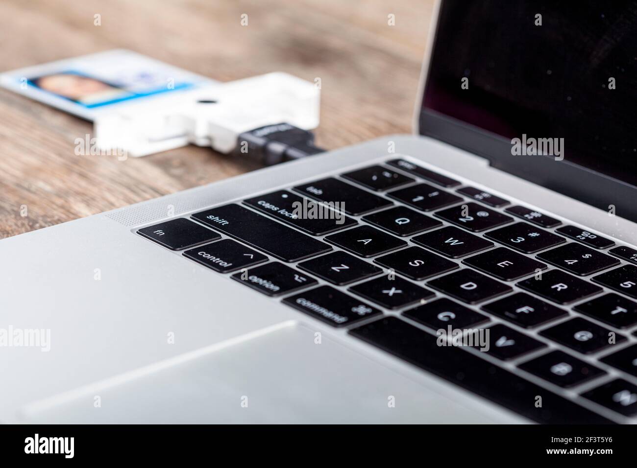 Una scheda di verifica dell'identità personale (PIV) viene utilizzata per accedere a un computer dell'area di lavoro. La scheda contenente un chip è collegata al computer portatile tramite l'auto Foto Stock