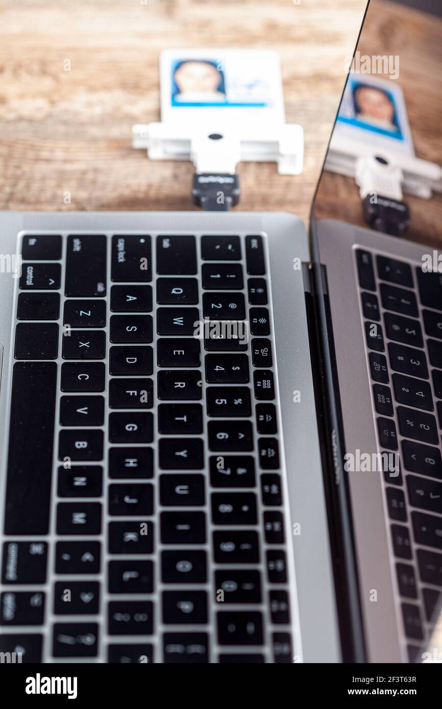 Una scheda di verifica dell'identità personale (PIV) viene utilizzata per accedere a un computer dell'area di lavoro. La scheda contenente un chip è collegata al computer portatile tramite l'auto Foto Stock
