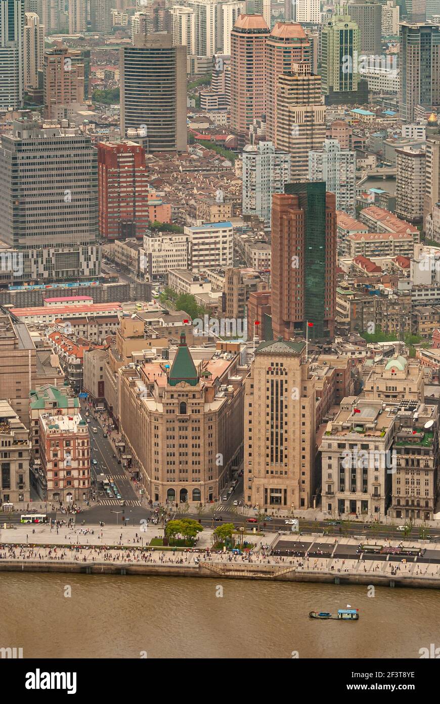 Shanghai, Cina - 4 maggio 2010: Triangolare con guglia verde costruzione di pace e snella Banca della Cina edificio con bandiere rosse lungo Bund e fiume. Urba Foto Stock