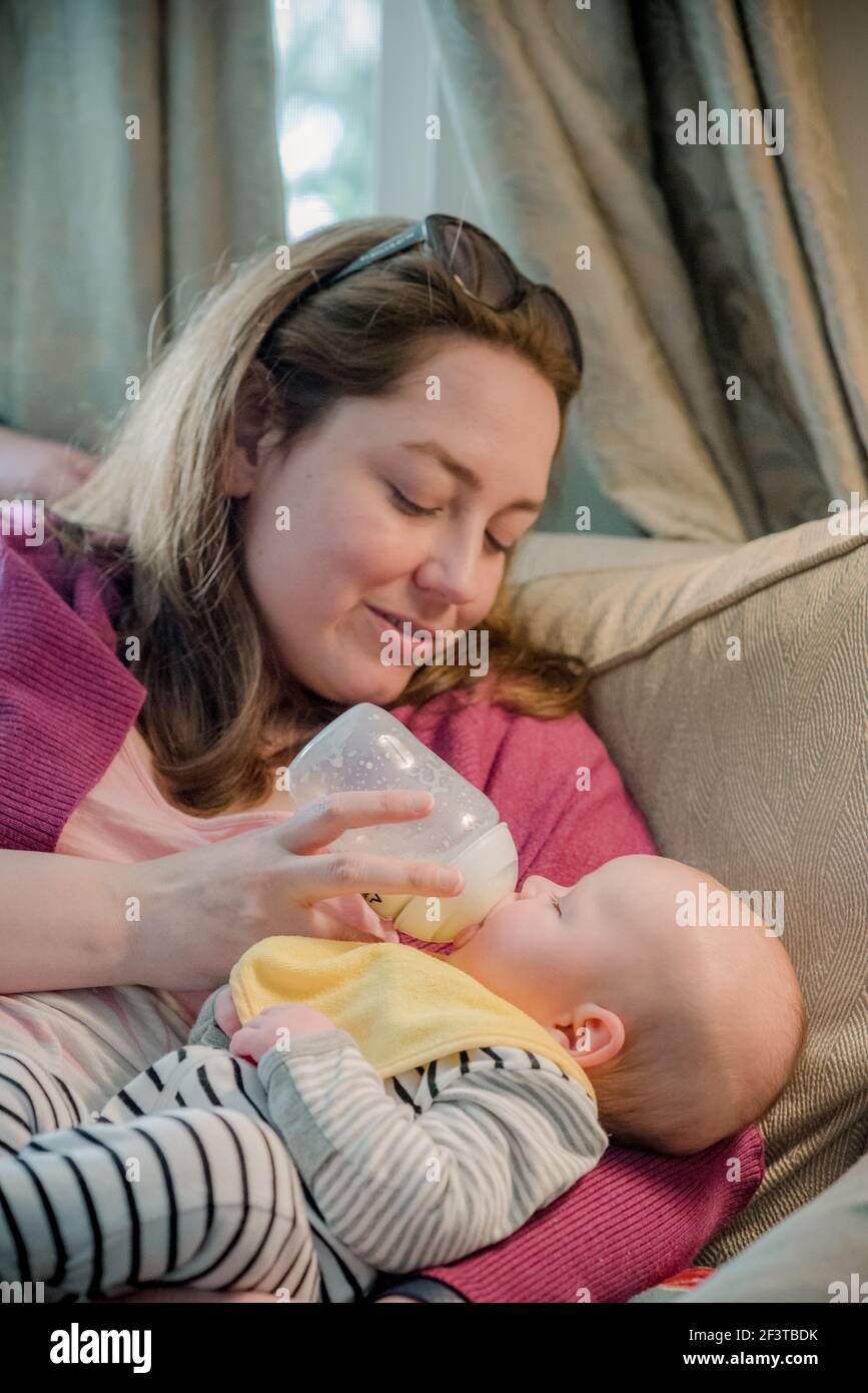 Madre che alimenta il bambino un biberon di formula Foto Stock
