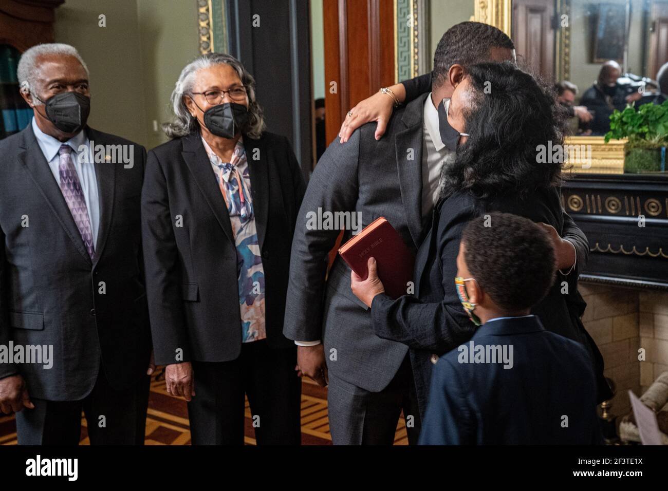 Da dietro. 17 Marzo 2021. L'amministratore dell'EPA Michael Regan riceve un abbraccio dalla moglie Melvina Thomas Regan, dopo essere stato giurato per cerimonie dal vice presidente degli Stati Uniti Kamala Harris nell'Eisenhower Executive Office Building di Washington, Stati Uniti, 17 marzo 2021. La madre di Regan, Mavis Artis Regan, e il padre Zeb Stuart Regan guardano da dietro. Credit: Ken Cedeno/Pool via CNP | Usage worldwide Credit: dpa/Alamy Live News Foto Stock
