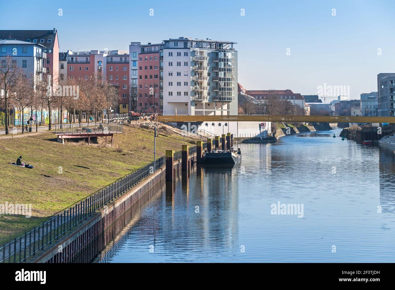 Berlino, Germania - 1 marzo 2021: Prato per prendere il sole al porto di Nordhafen con il nuovo ponte Golda-Meir-Steg in costruzione sopra il Berlin-Spandau sh Foto Stock