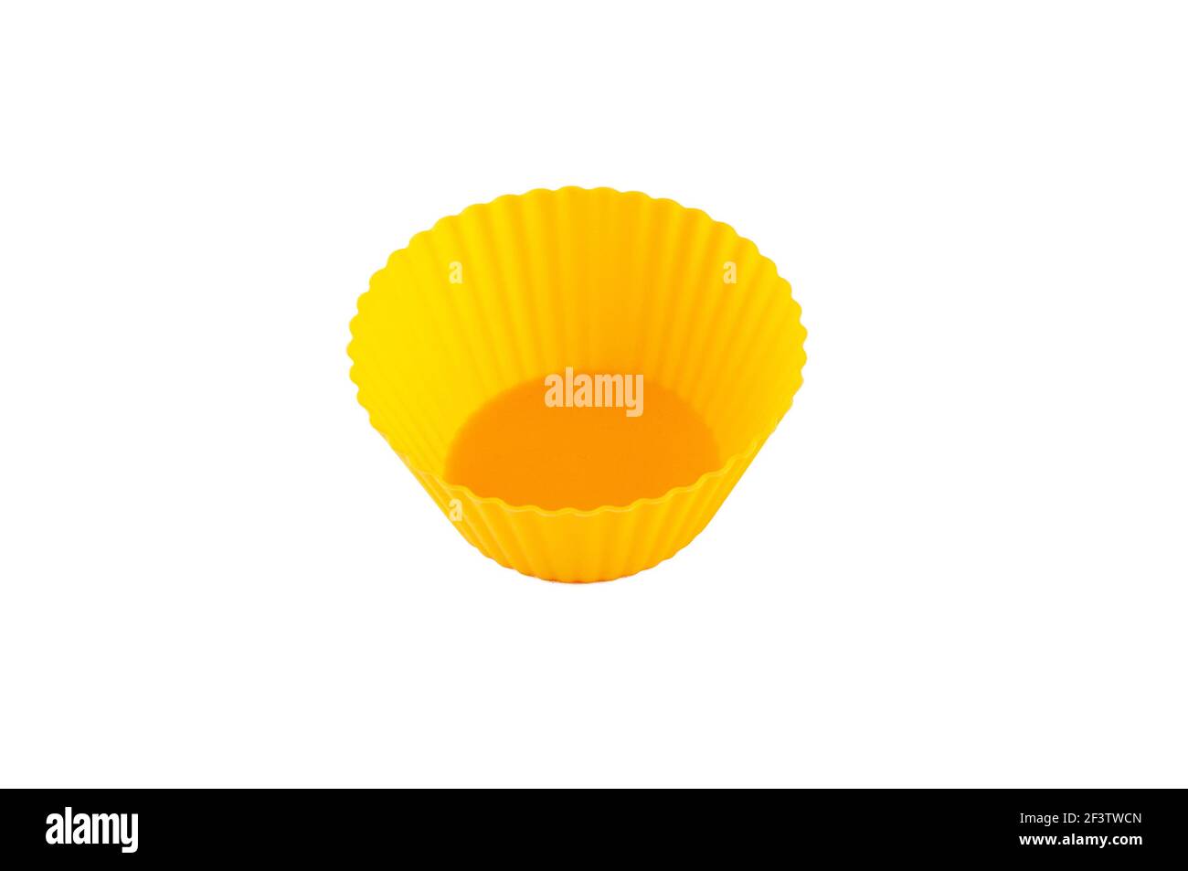 Stampi in silicone giallo arancio per la cottura di muffin e cupcake isolati su bianco. Foto Stock