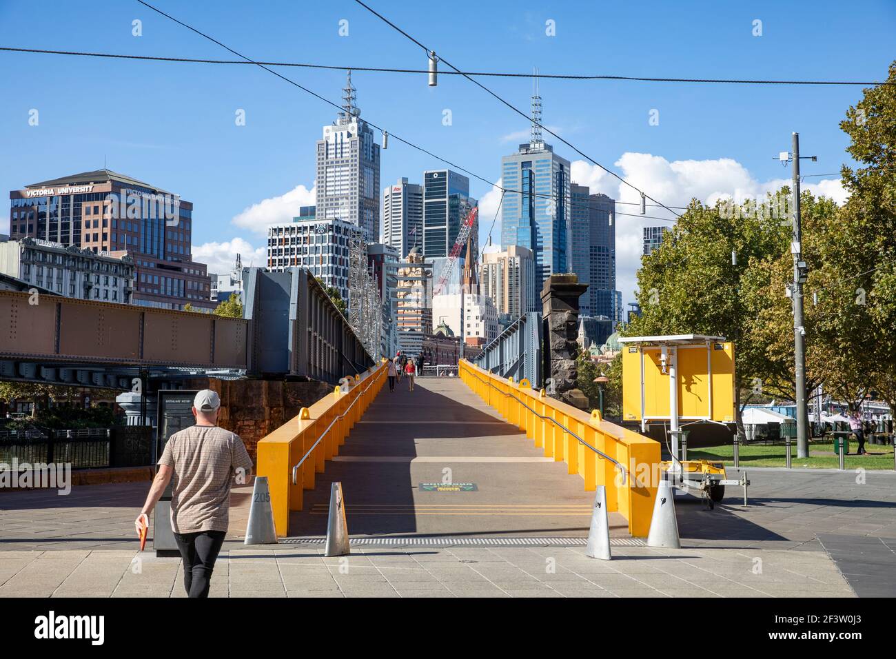 Le persone del centro di Melbourne entrano nel ponte Sandridge attraverso il fiume Yarra, Melbourne, Australia Foto Stock