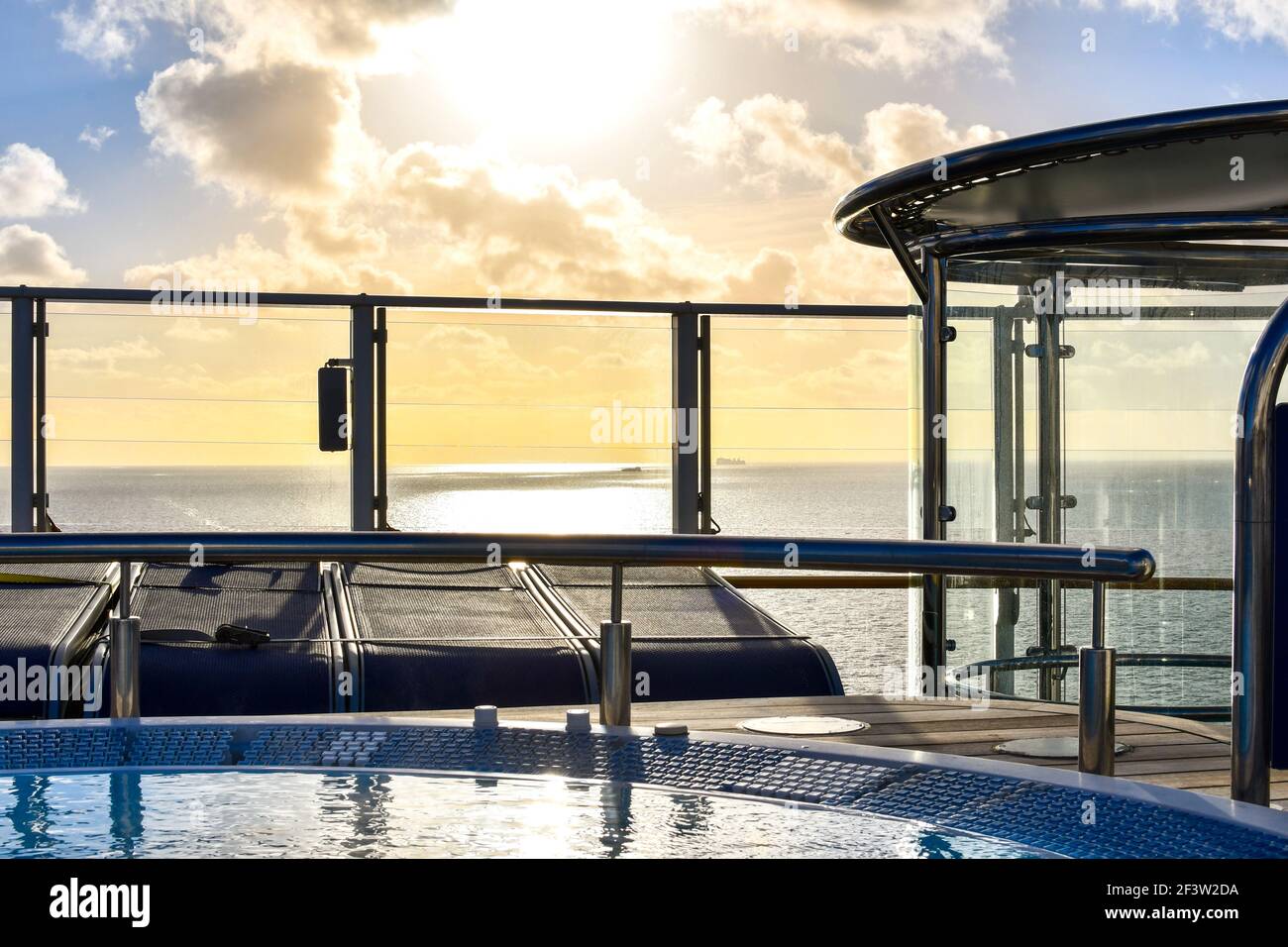 La luce del sole si riflette sul mare e due navi viste da una vasca idromassaggio sul ponte superiore di una nave da crociera. Foto Stock