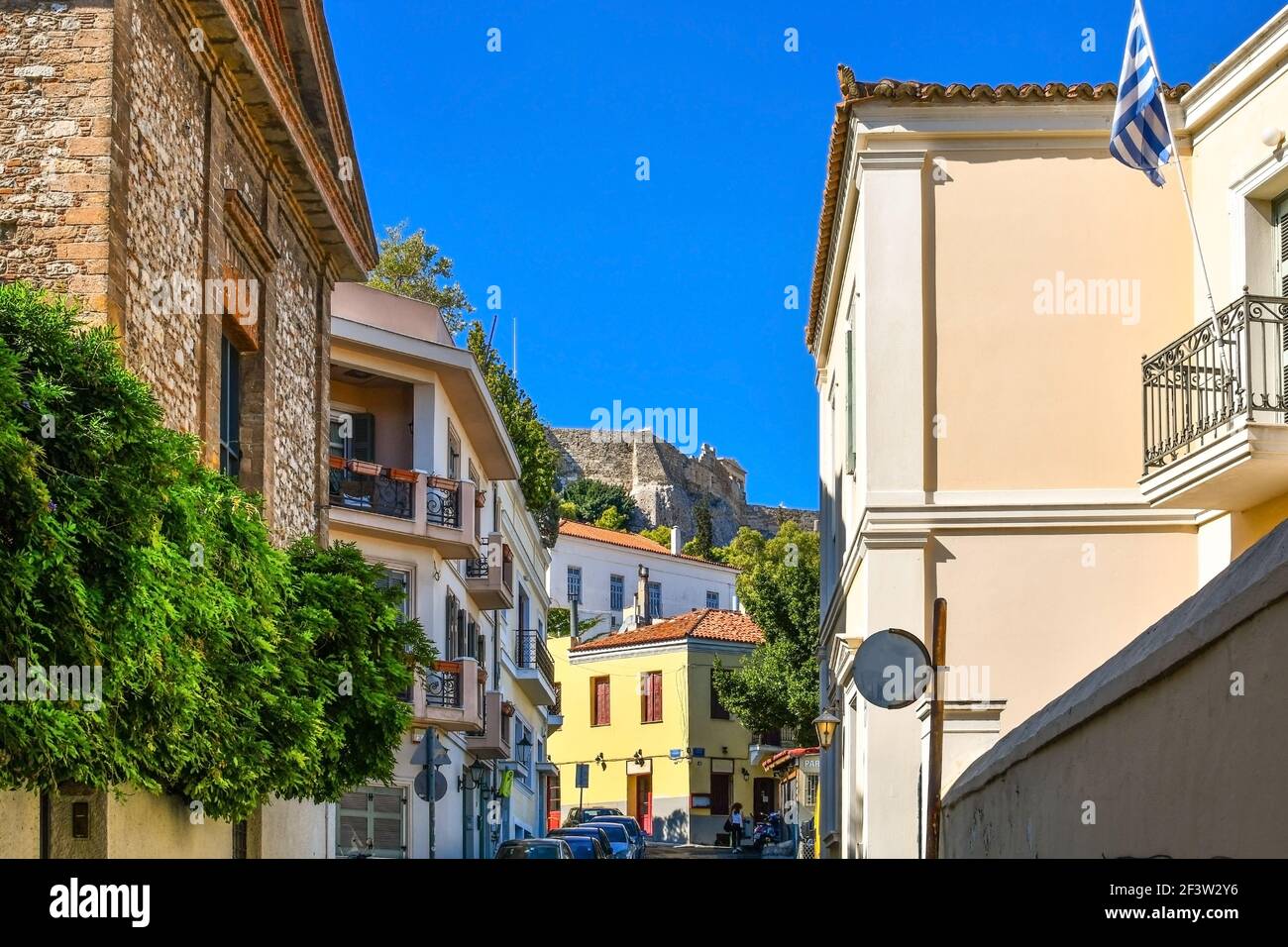 Vista di una porzione della collina dell'Acropoli dalle colorate strade residenziali del quartiere di Plaka ad Atene, Grecia. Foto Stock