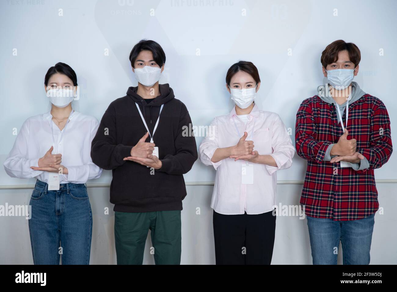 Giovane squadra asiatica con covid campagna di consapevolezza segni di mano Foto Stock