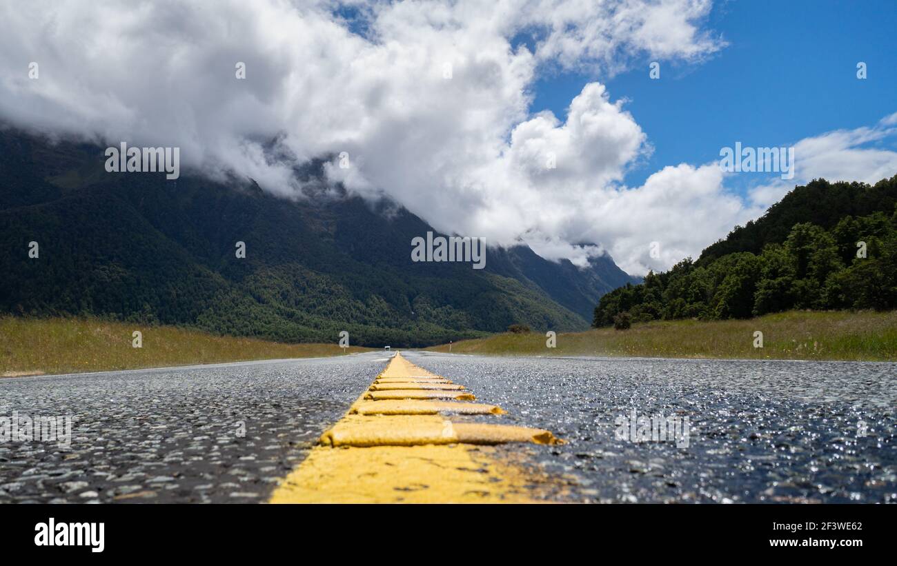 Milford Road con linea gialla nel mezzo, Fiordland National Park, Nuova Zelanda Foto Stock
