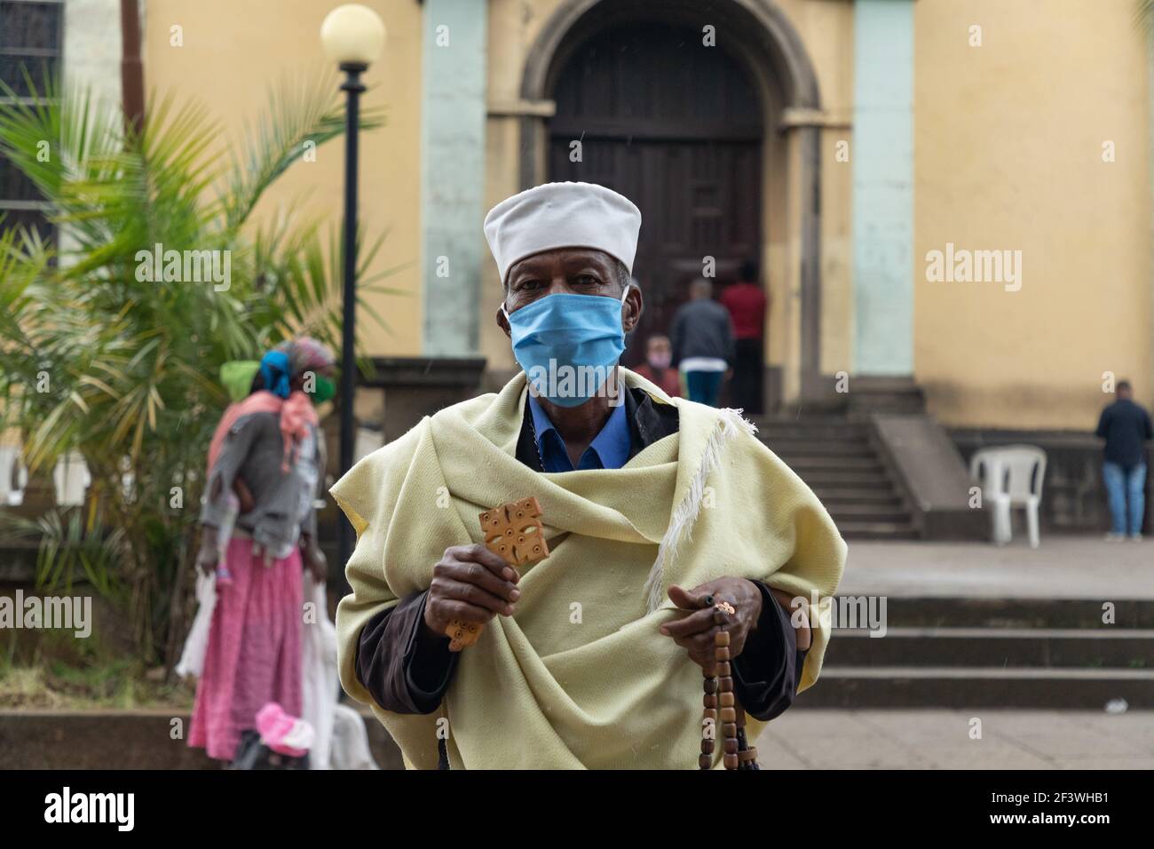 Addis Abeba / Etiopia - Giugno 14 2020: Etiope cristiano ortodosso Tewaheddo Chiesa sacerdote nella chiesa della Santa Trinità. Lavorare mentre si indossa una maschera. Foto Stock