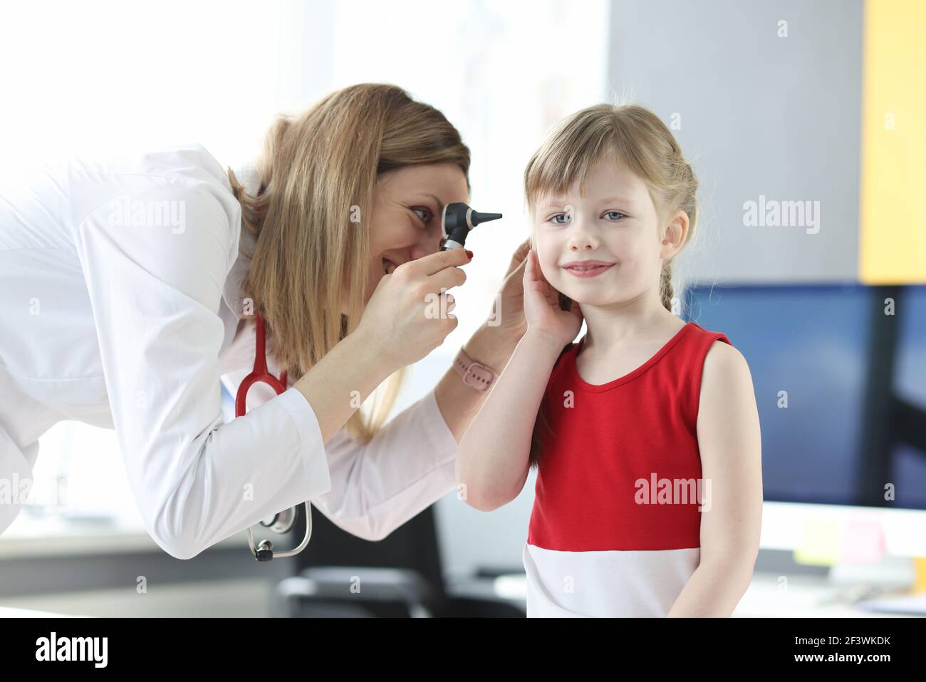 Un otolaringologo esamina l'orecchio della bambina Foto Stock