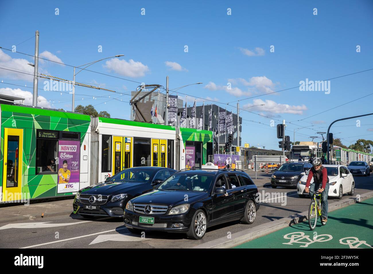 Le modalità di trasporto, bicicletta, tram e auto del centro di Melbourne lasciano il ponte Princes nel centro della città, Victoria, Australia Foto Stock