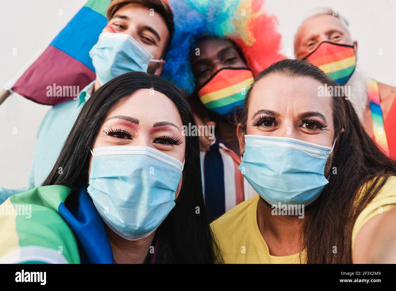 Amici gay multirazziali che prendono un selfie alla parata LGBT durante Focolaio di coronavirus - fuoco sul fronte destro della regina di resistenza Foto Stock