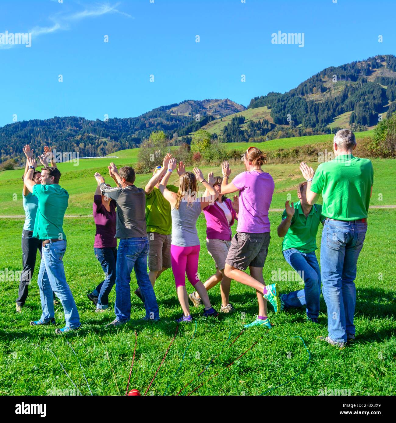 Un gruppo durante un esercizio di team building - riuscire attraverso il lavoro di squadra e il coordinamento tra di loro Foto Stock