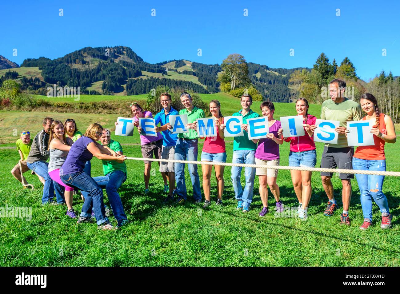 Un gruppo durante un esercizio di team-building - solo quando si tirano insieme si può avere successo in Torg-of-war. Foto Stock