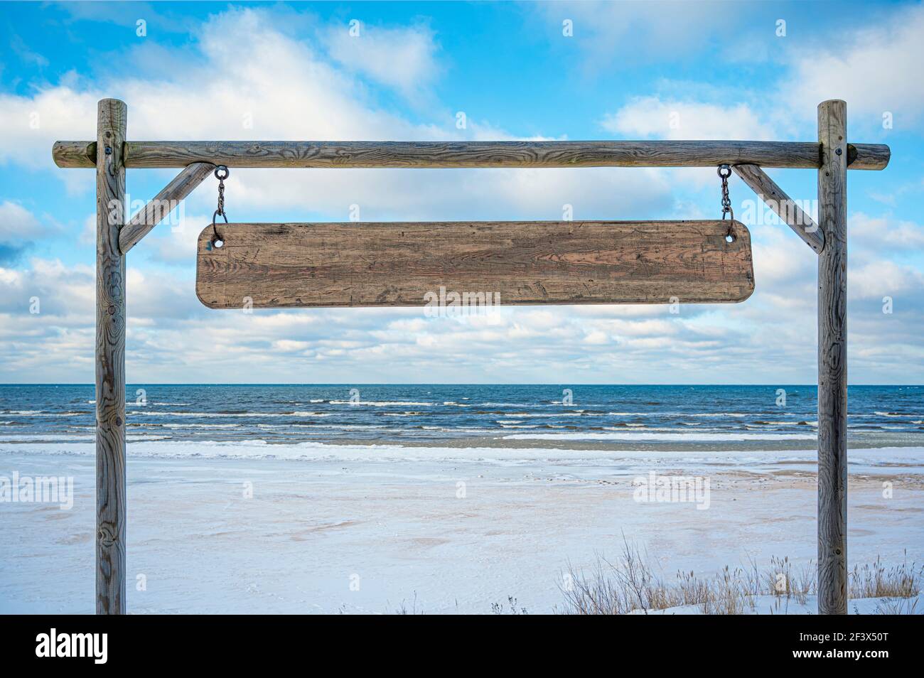 Cartello in legno con spazio copia su cielo blu e mare con sfondo onde. Cartello di legno vuoto. Foto Stock