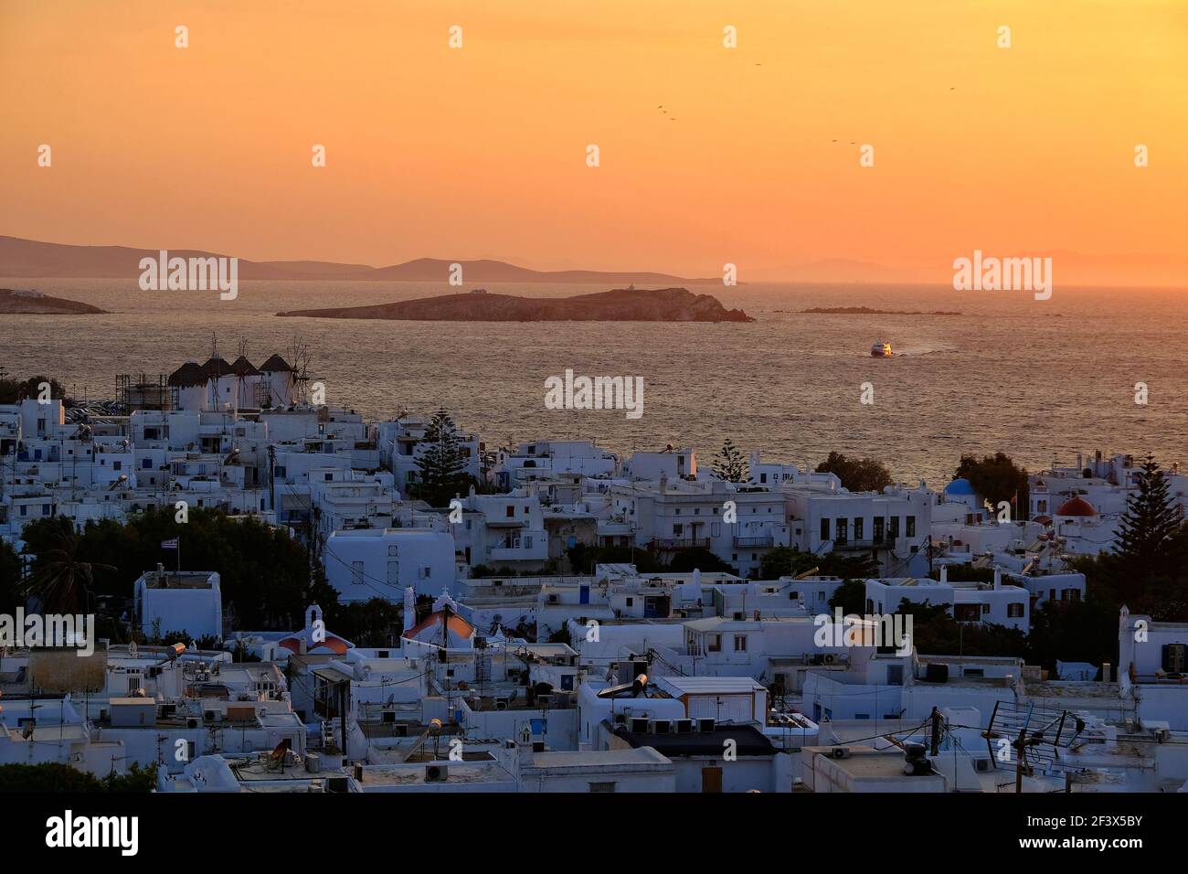 Vista panoramica della città di Mykonos mentre il sole è ambientazione drammatica Foto Stock