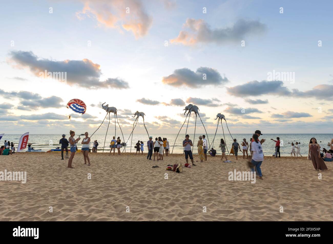 Turisti in visita alla famosa installazione sulla spiaggia con elefanti su bastoni, la spiaggia Sunset Sanato Beach Club Foto Stock