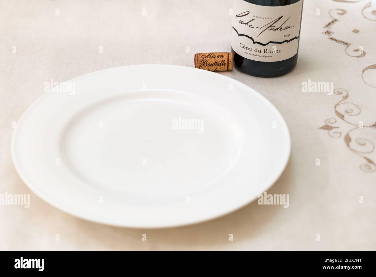 Piatto bianco puro vuoto con bottiglia di Cote du Rhone Roche Audran vino rosso francese e tappo di vino Foto Stock