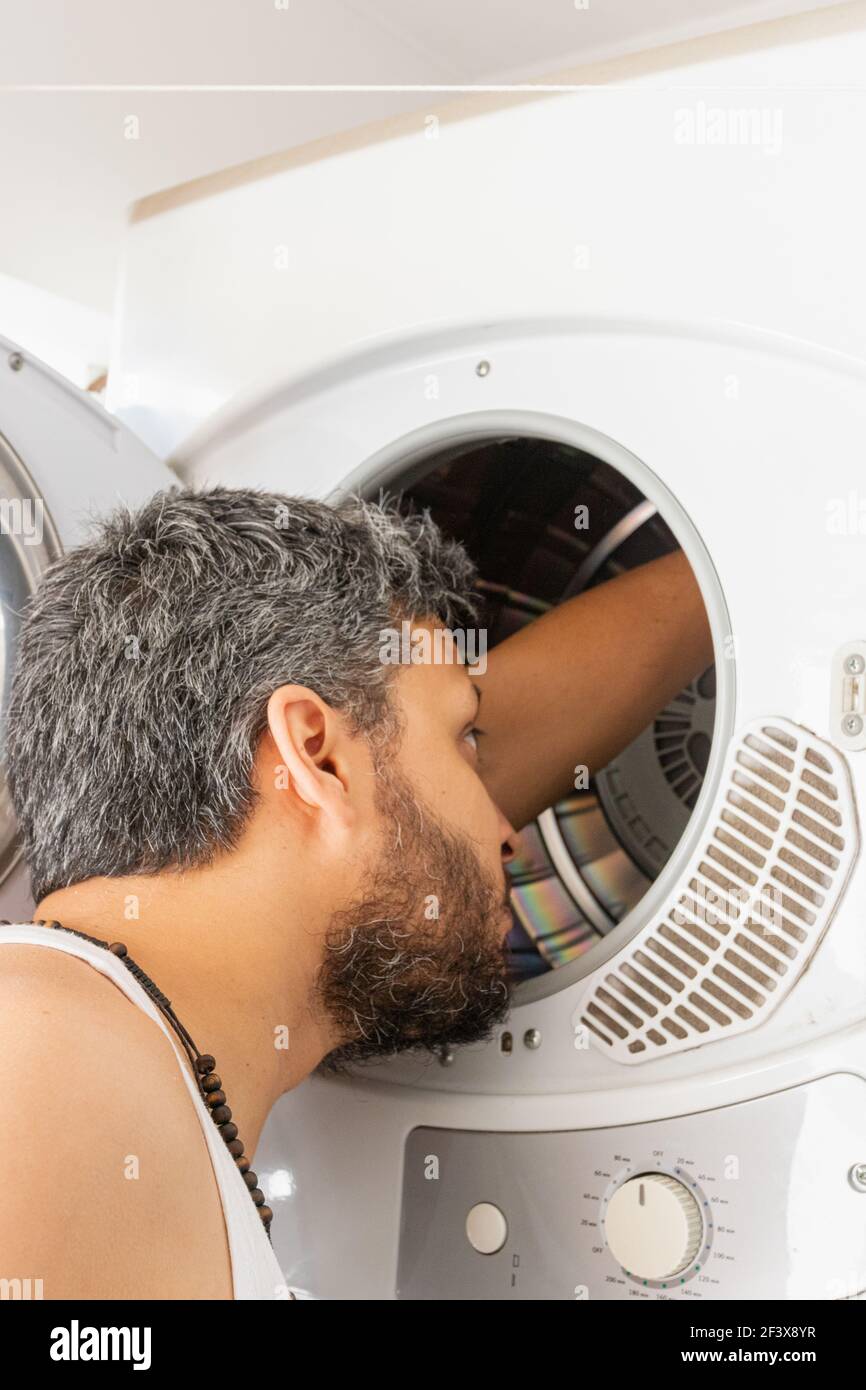 Giovane uomo con archetto che va lavare la vostra lavanderia sporca Foto Stock