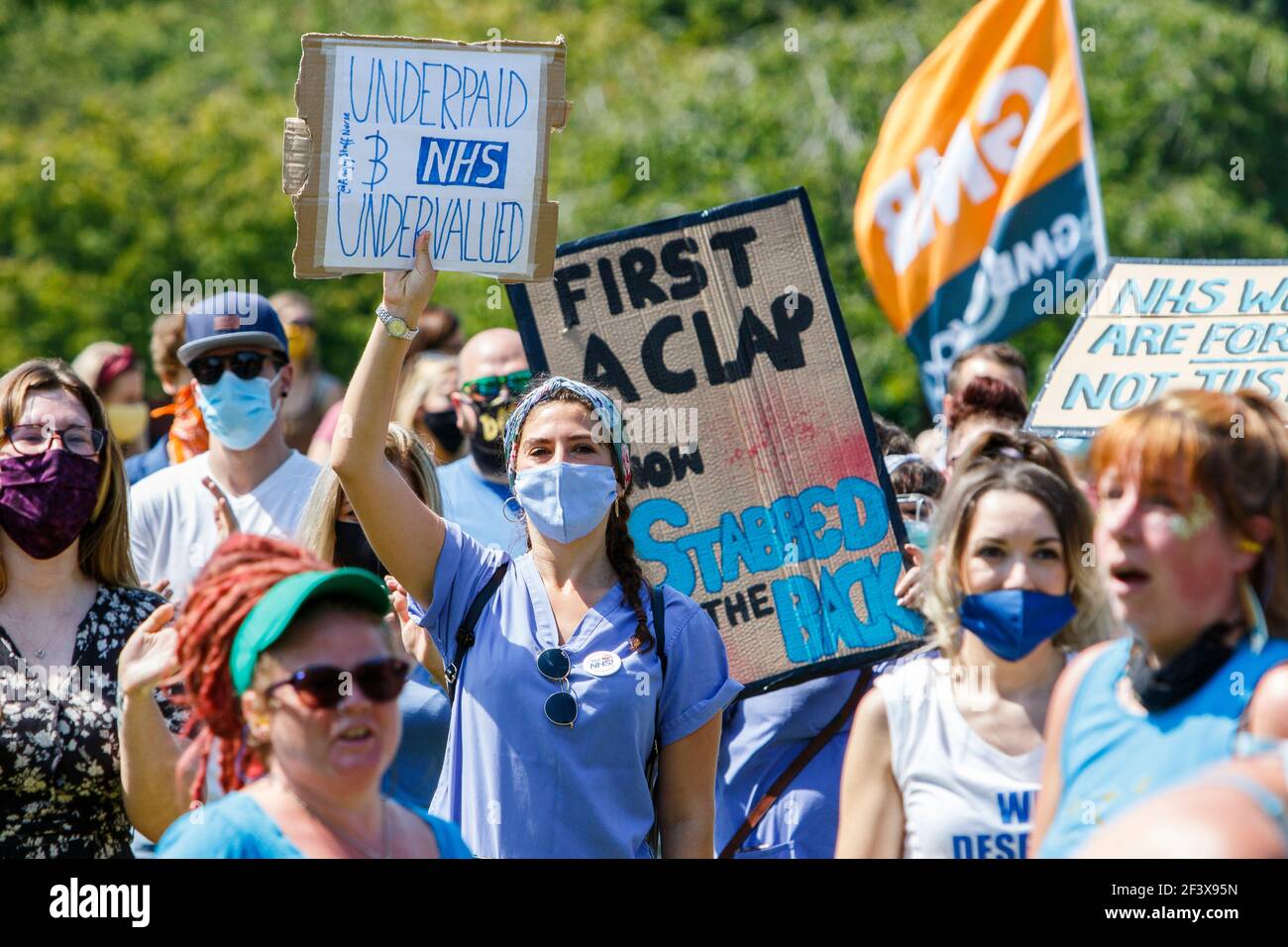 I manifestanti che trasportano un cartello sono raffigurati mentre prendono parte ad una manifestazione e una marcia di protesta dei lavoratori della NHS ‘pay justice’ a Bristol, l’8 agosto 2020 Foto Stock