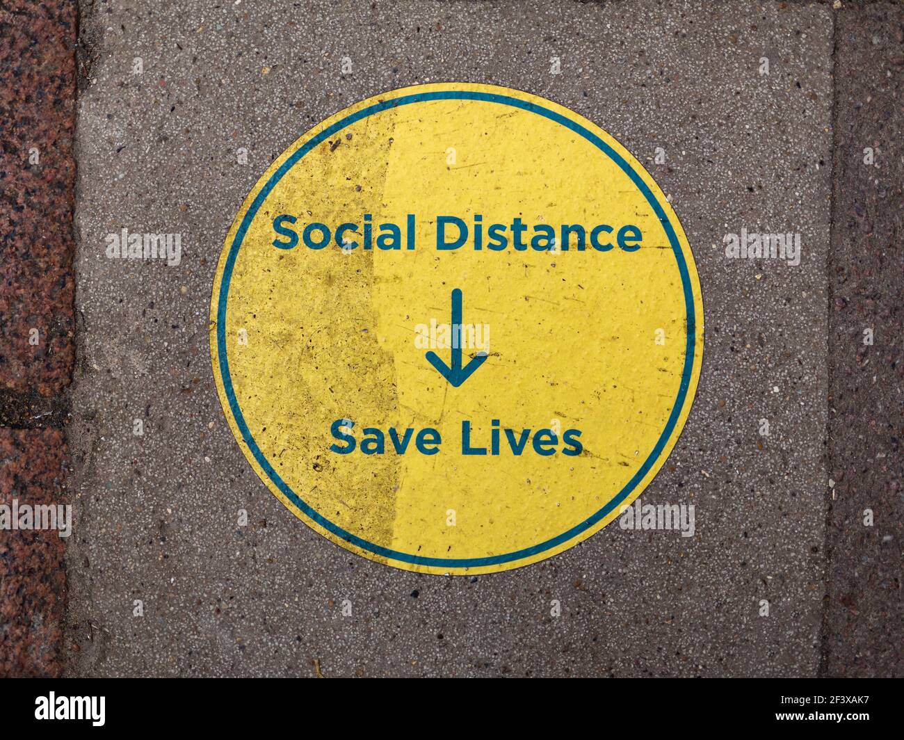 Un cartello che informa il pubblico che l'allontanamento sociale salva vite umane durante la pandemia globale del virus della corona. Covid 19 restrizioni pandemiche. Foto Stock