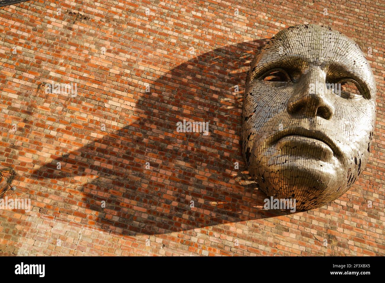 Scultura metallica, faccia gigante. Arte pubblica a Lincoln City, fuori dal luogo chiamato la Drill Hall, Rick Kirby, acciaio inossidabile, piccole strisce di metallo. Foto Stock