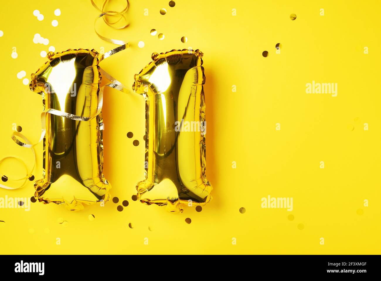 Numero di palloncino in oro, cifra undici. Biglietto d'auguri per compleanno, iscrizione 11. Evento di celebrazione dell'anniversario. Banner. Elegante numero dorato, luminoso Foto Stock