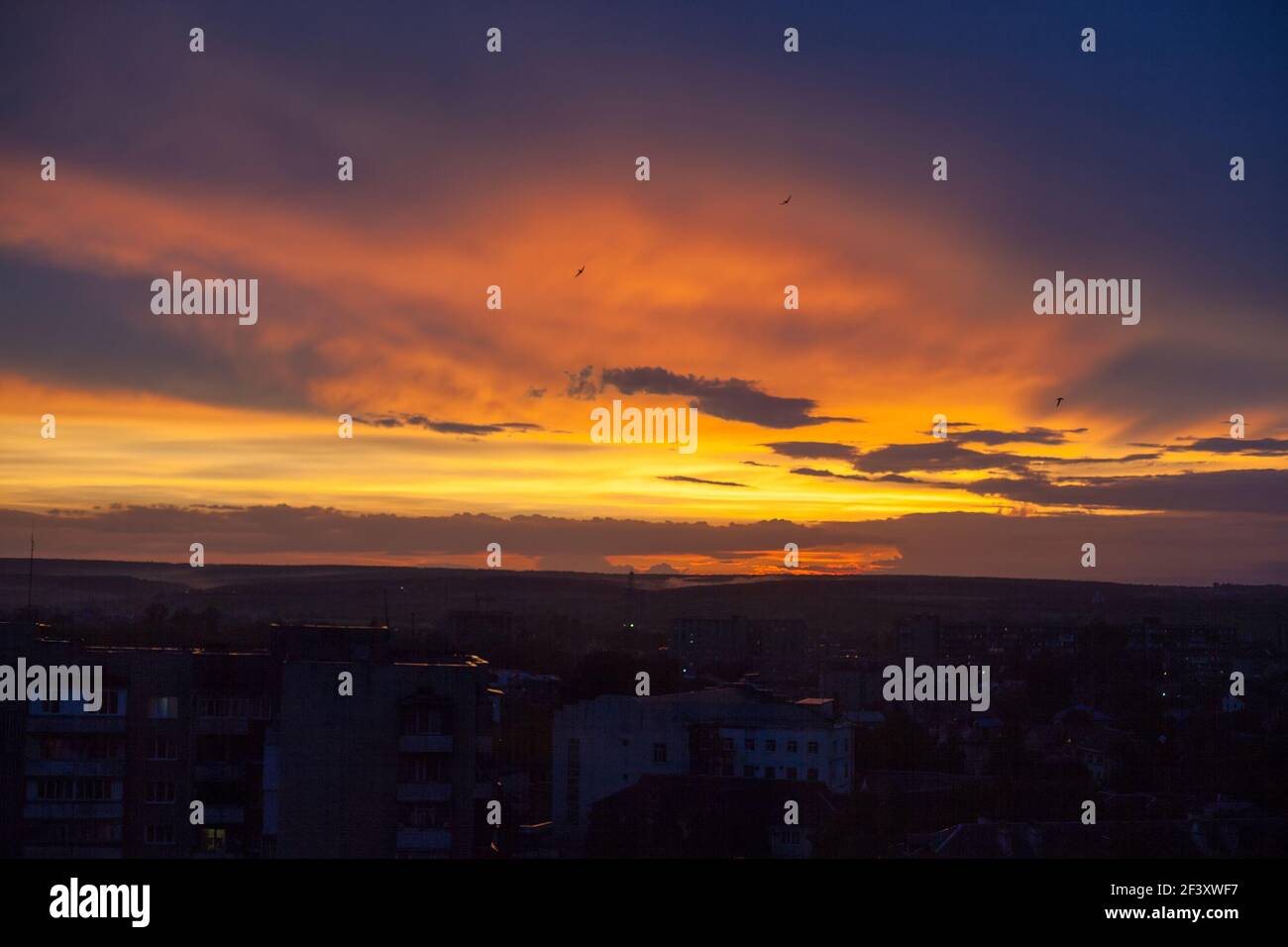 Suggestivo cielo nuvoloso al tramonto giallo, arancione e viola Foto Stock