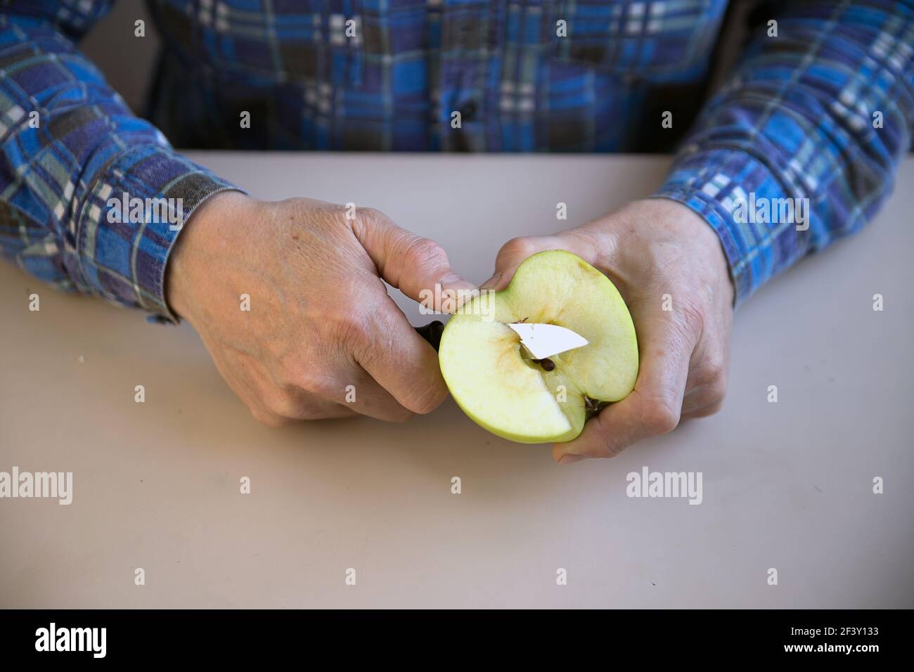 L'uomo taglia la mela con il coltello sulle fette Foto stock - Alamy