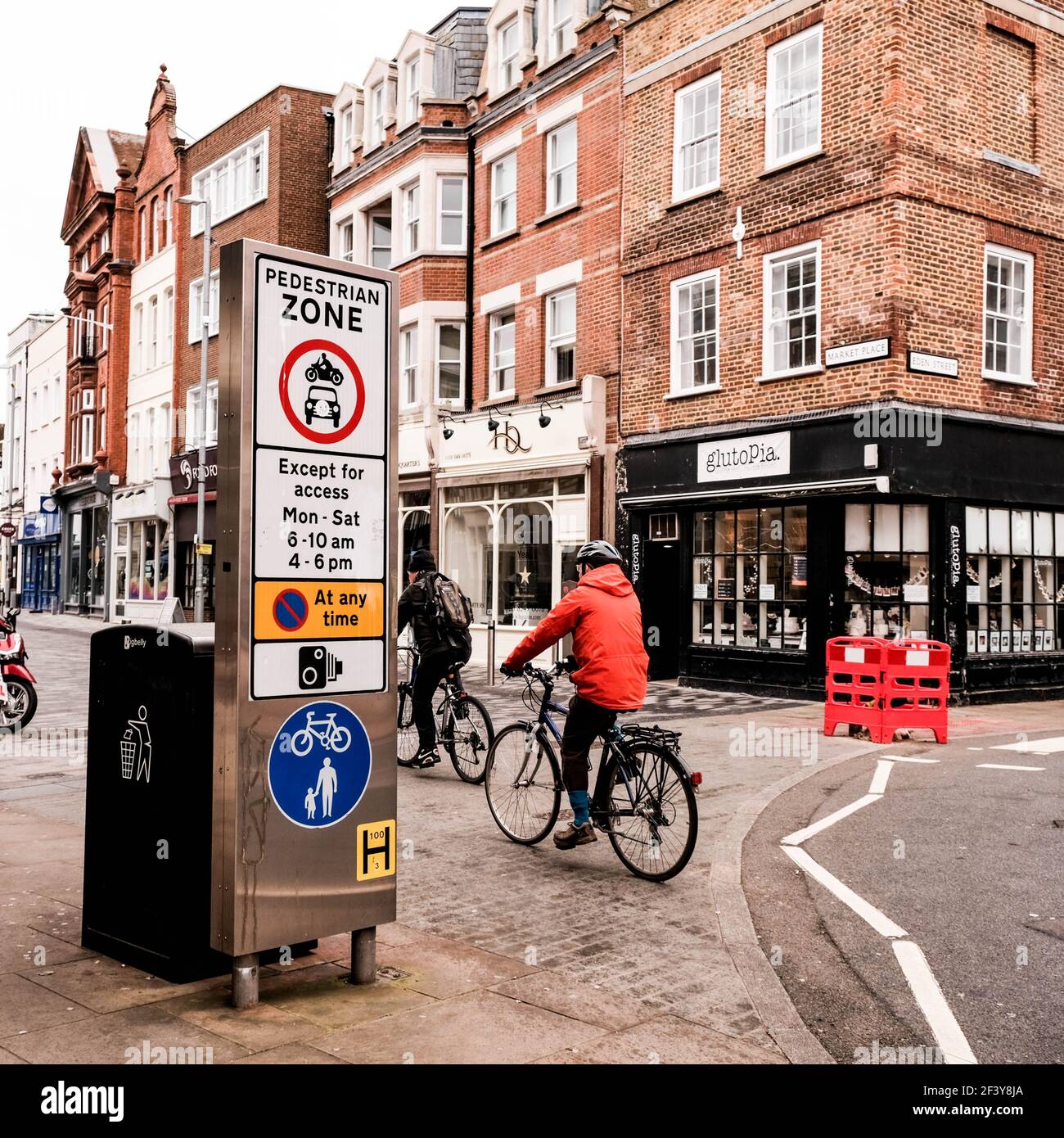 Londra UK, marzo 18 2021, ciclisti che attraversano una piazza del mercato vuota a Kingston-upon Thames Foto Stock