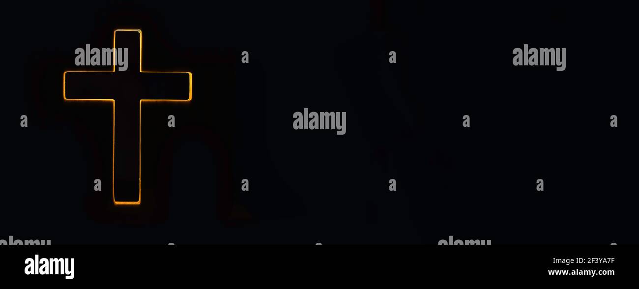 Silhouette di croce cristiana, luci, bokeh su sfondo nero. Spazio di copia. Simbolo di fede. Culto della Chiesa, concetto di salvezza. Simbolo della fede in Gesù Foto Stock