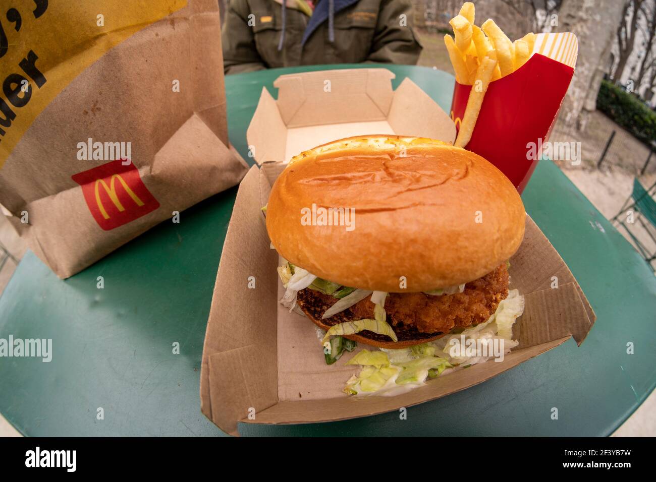 New York, Stati Uniti. 17 Marzo 2021. Un ristoratore si prepara a pranzo su un McDonald's Crispy Chicken Sandwich Deluxe mentre cena all'aperto a New York mercoledì 17 marzo 2021. Nel 2019 Popeye's ha debuttato il suo sandwich di pollo con grande successo, portando quasi ogni catena di fast food a generare un piatto di pollo croccante. McDonald's è finalmente entrato come il 800-lb gorilla e ha già portato ad una spinta di traffico piede nei suoi ristoranti. (Foto di Richard B. Levine) Credit: Sipa USA/Alamy Live News Foto Stock