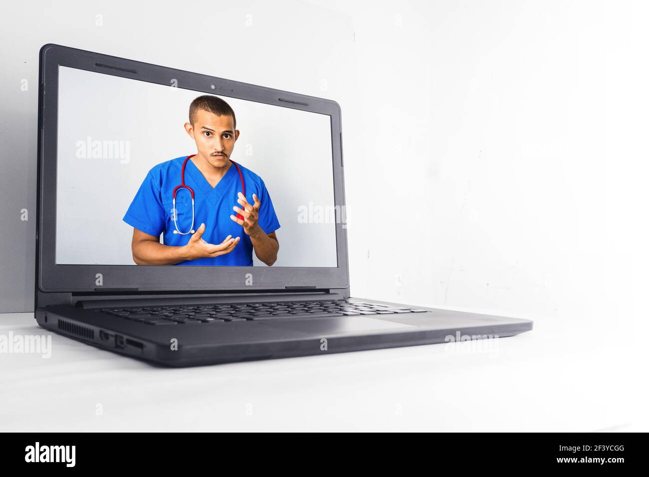 Un closeup di un giovane medico maschile honduran che fa un consultazione medica online sul portatile Foto Stock