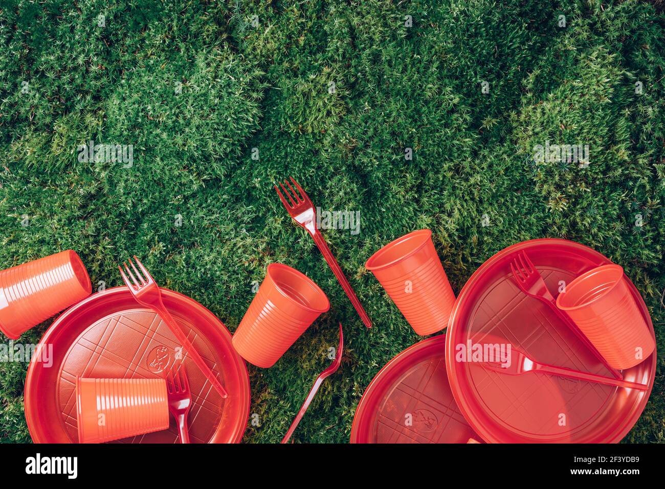 Riciclaggio di plastica ed ecologia. Stoviglie in plastica monouso - piastre, forcelle, cucchiai, coltelli. Vista dall'alto. Spazio di copia. Inquinamento ambientale. Rosso Foto Stock