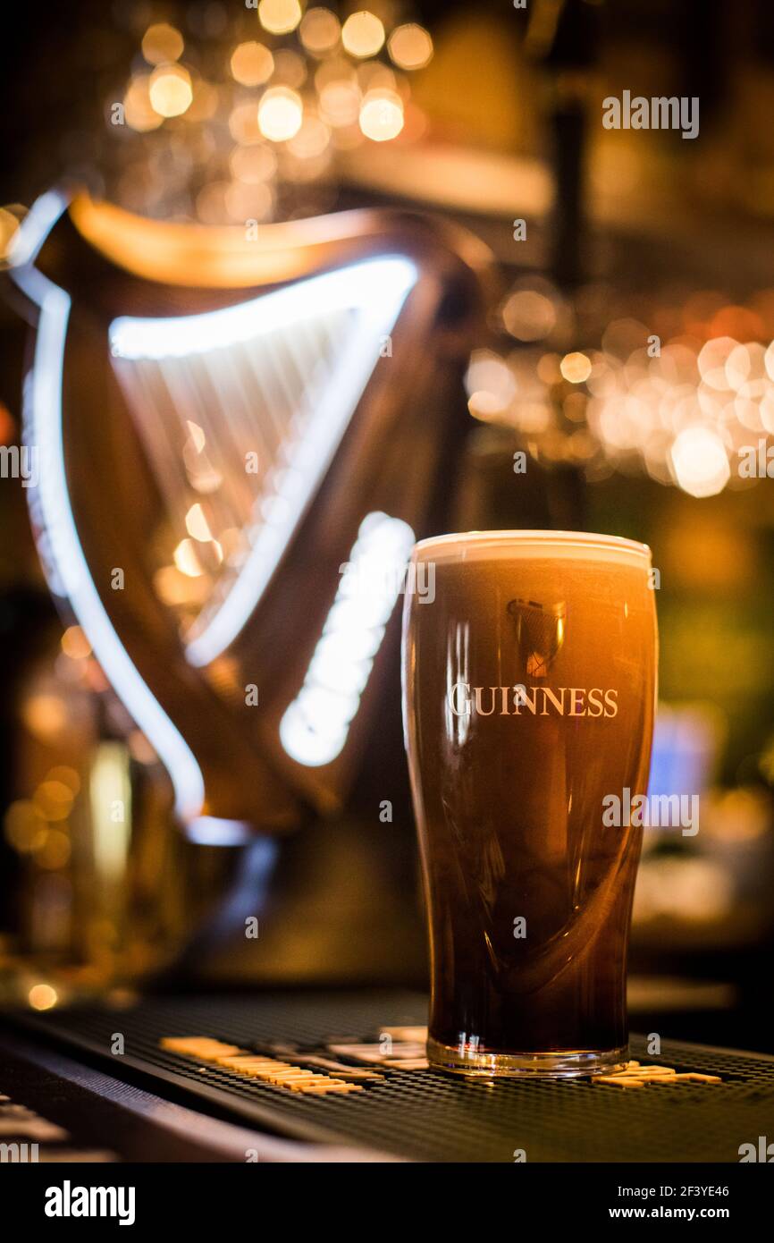 Bucarest, Romania - 25 febbraio 2021: Immagine editoriale di primo piano illustrativa di una pinta di birra Guinness sul bancone di un pub. Foto Stock