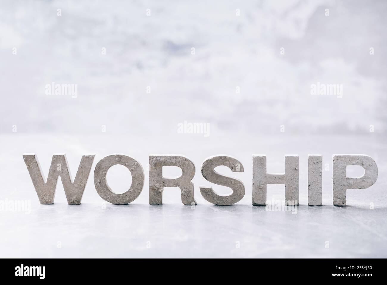 Culto di parola fatto con lettere di cemento su sfondo grigio marmo. Spazio di copia. Promemoria biblico, spirituale o cristiano. Venerdì Santo, giorno di Pasqua Foto Stock