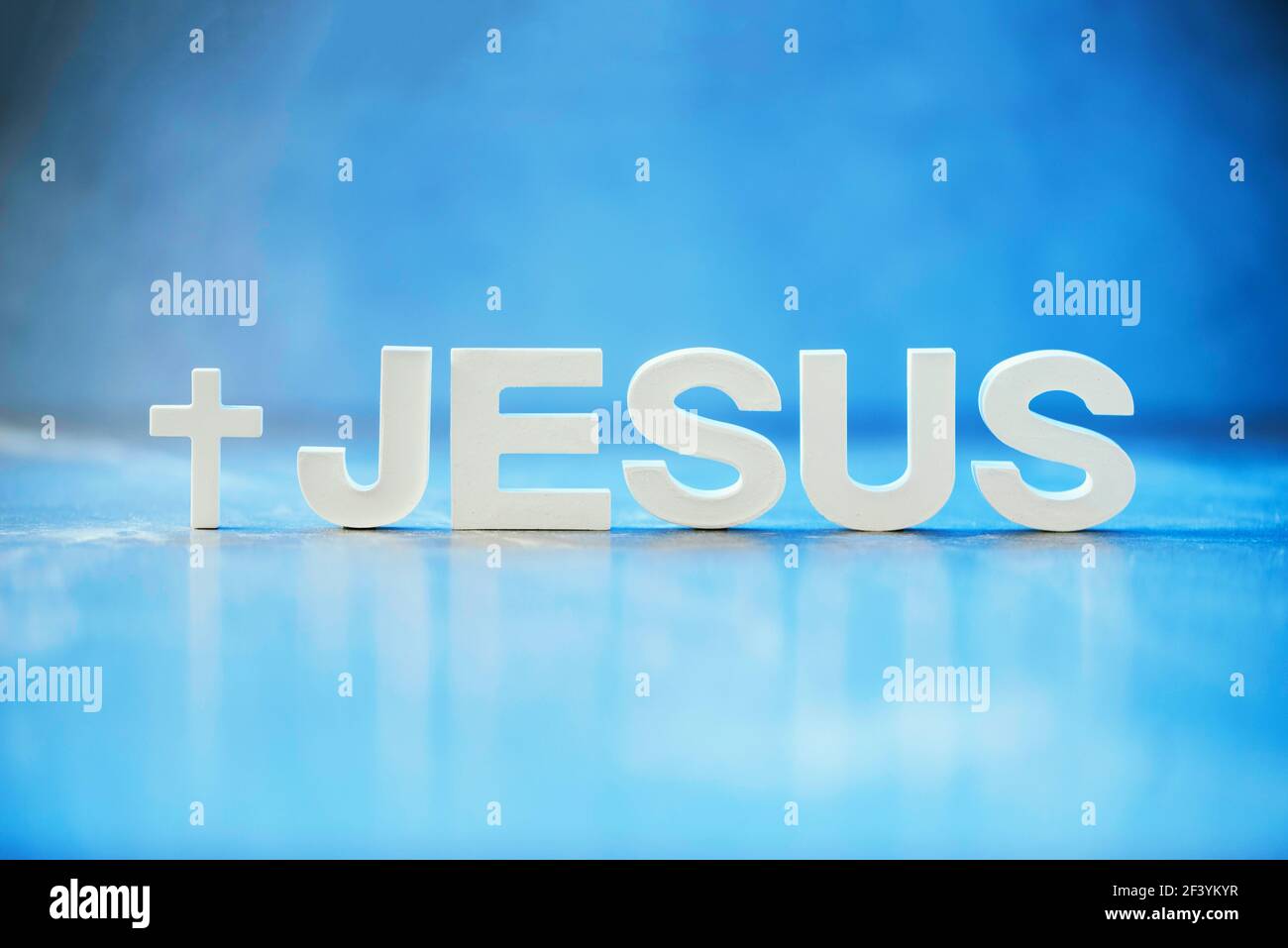 Nome GESÙ fatto con lettere di cemento su sfondo blu chiaro marmo. Spazio di copia. Promemoria biblico, spirituale o cristiano Foto Stock