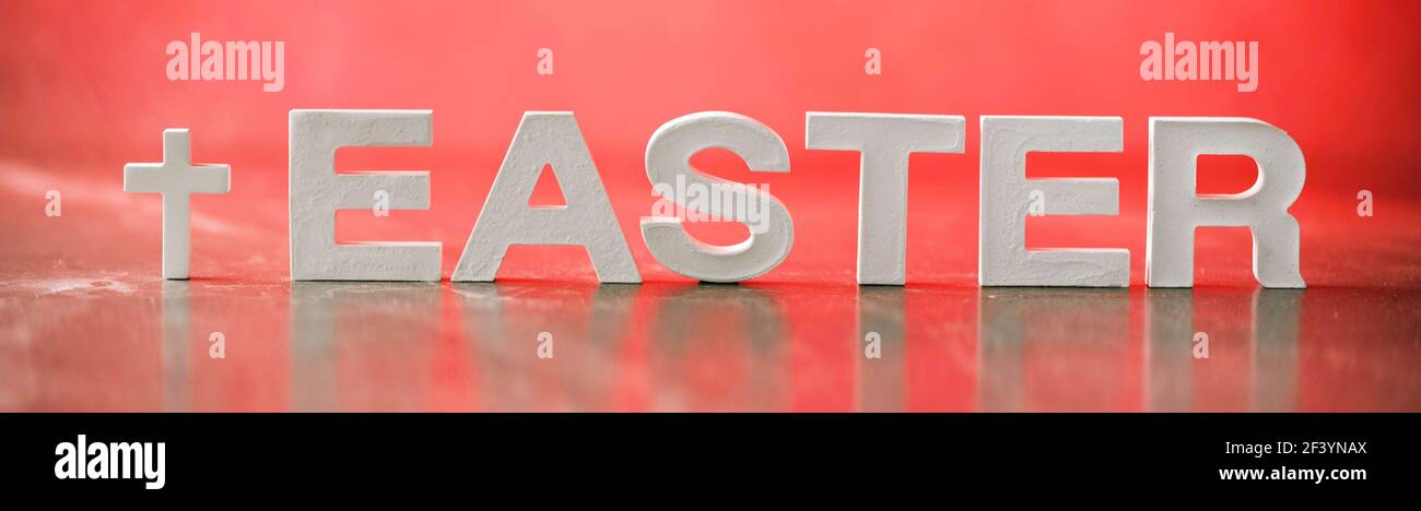 Parola Pasqua fatta con lettere di cemento su sfondo di marmo rosso. Promemoria biblico, spirituale o cristiano. Concetto di Pasqua cristiana. Crocifissione Foto Stock