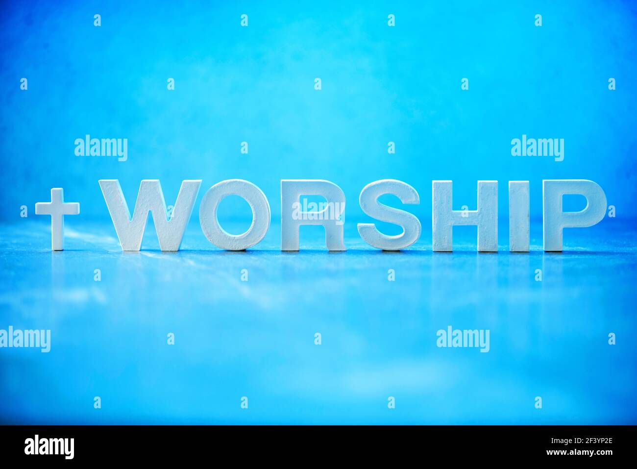 Adorazione di parola fatta con lettere di cemento su sfondo di marmo blu. Spazio di copia. Promemoria biblico, spirituale o cristiano. Venerdì Santo, giorno di Pasqua Foto Stock
