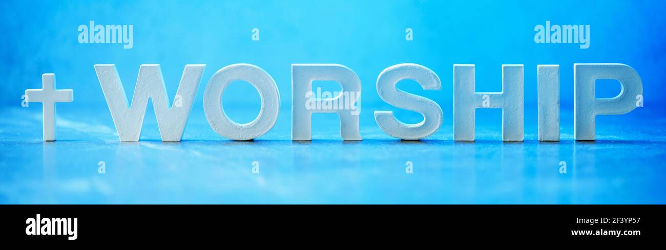 Adorazione di parola fatta con lettere di cemento su sfondo di marmo blu. Spazio di copia. Promemoria biblico, spirituale o cristiano. Venerdì Santo, giorno di Pasqua Foto Stock