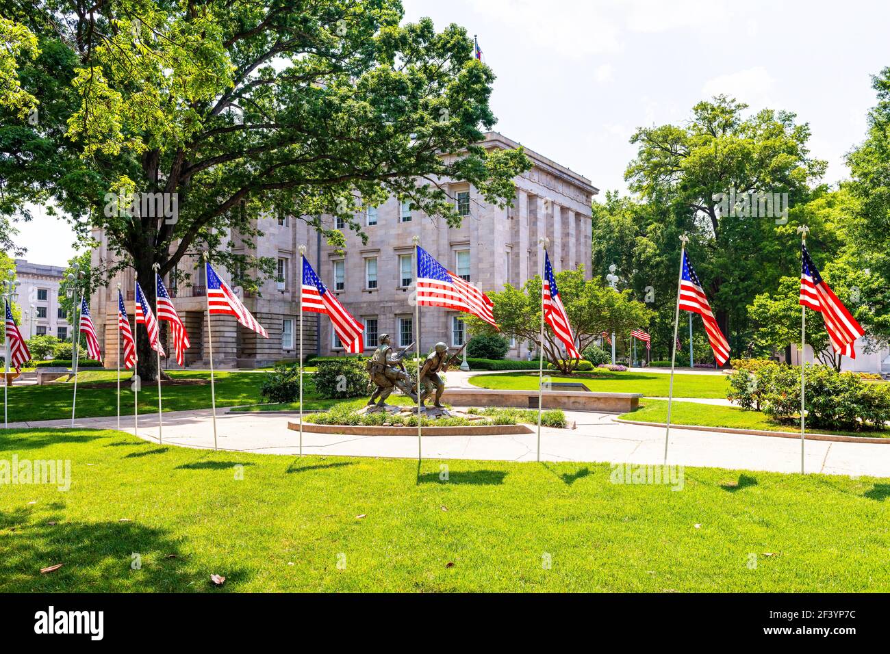 Raleigh, USA - 12 maggio 2018: Monumento ai veterani del Vietnam del North Carolina con tre soldati che trasportano il compagno ferito con la fila della bandiera americana Foto Stock