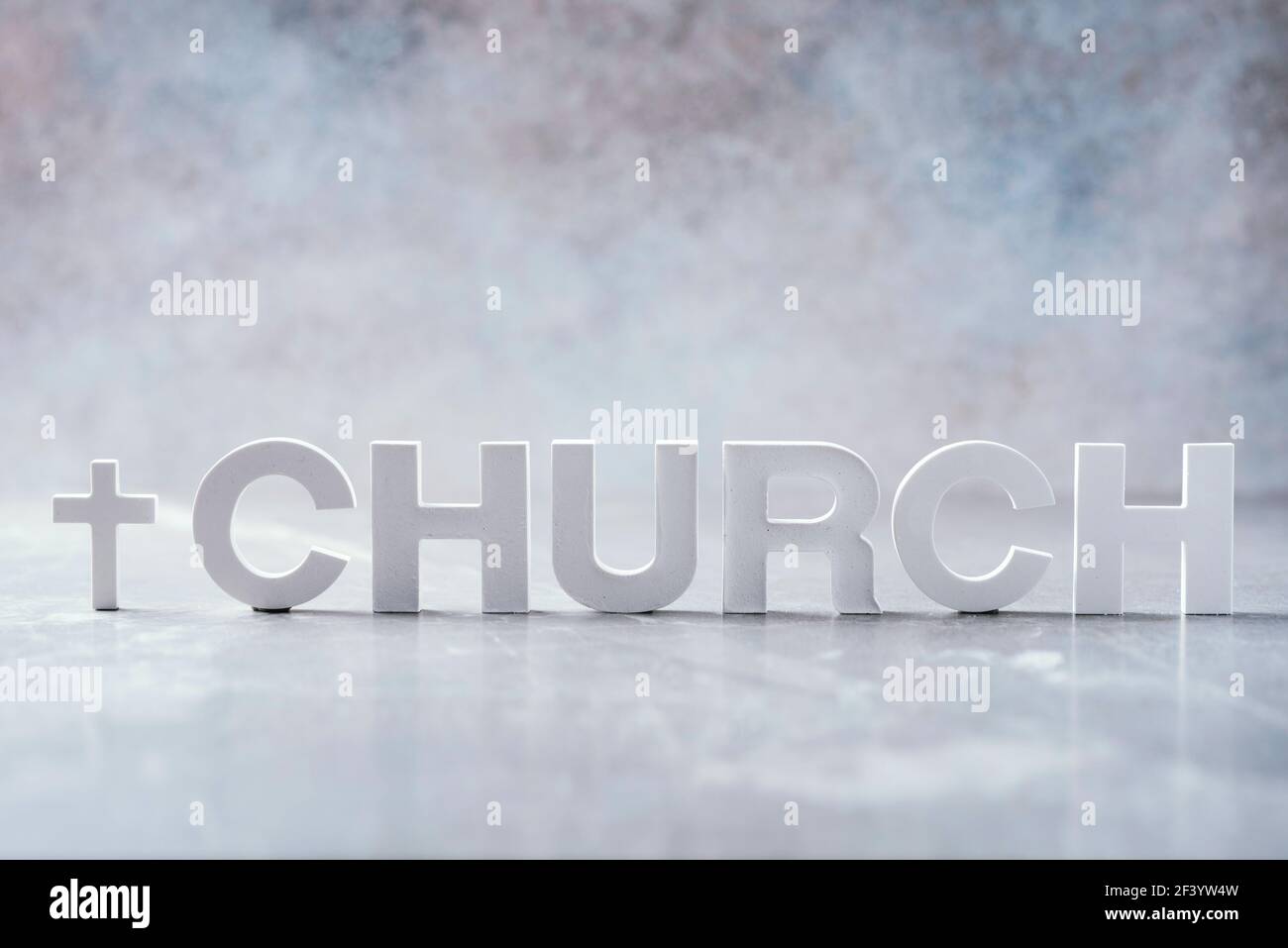 Parola Chiesa fatta con lettere di cemento e croce su sfondo grigio marmo. Spazio di copia. Promemoria biblico, spirituale o cristiano Foto Stock