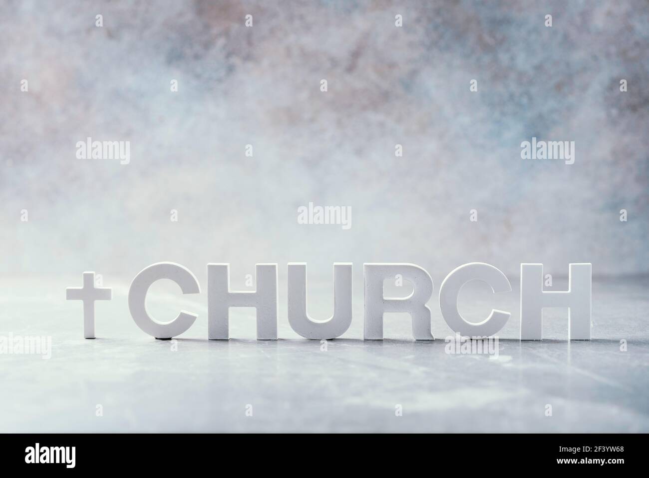 Parola Chiesa fatta con lettere di cemento e croce su sfondo grigio marmo. Spazio di copia. Promemoria biblico, spirituale o cristiano Foto Stock