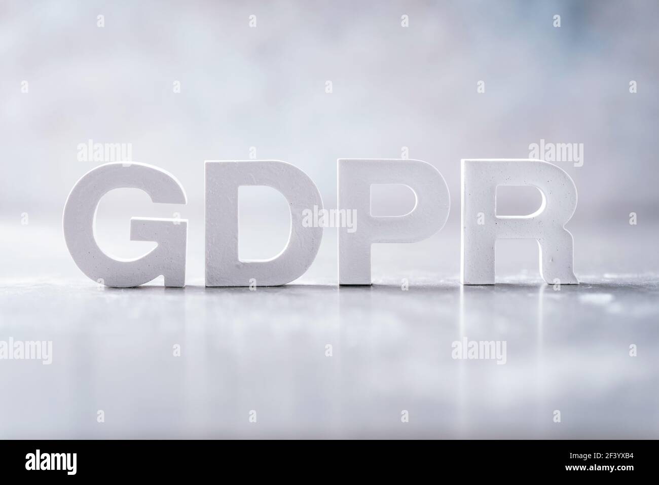 Parola GDPR (regolamento generale sulla protezione dei dati) realizzata con lettere in cemento su sfondo grigio in marmo. Spazio di copia Foto Stock
