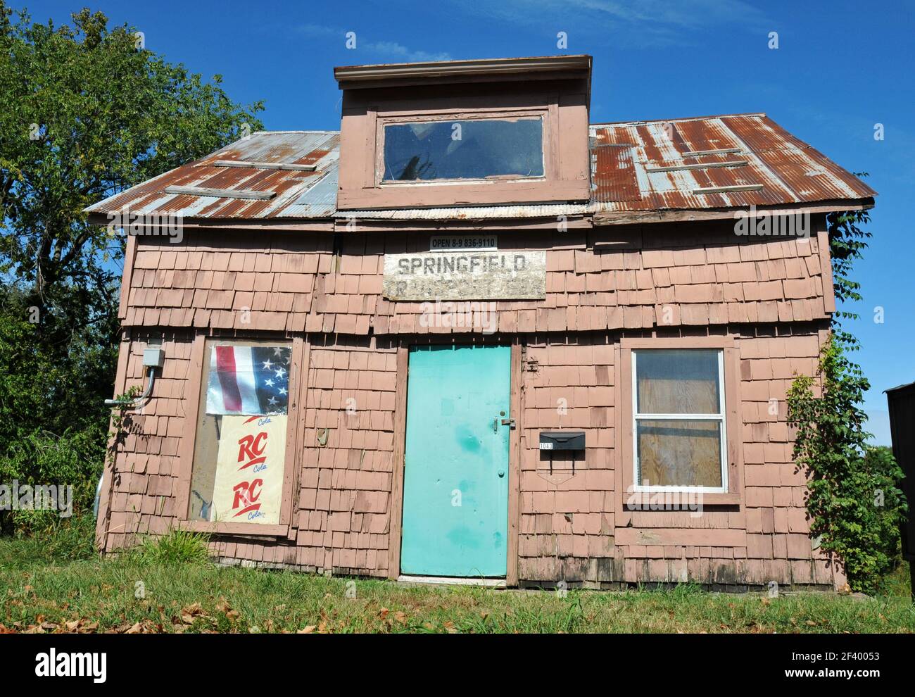 Una vecchia casa con un tetto di stagno arrugginita si trova sulla Route 66 a Springfield, Missouri. L'edificio è stato utilizzato come proprietà commerciale negli ultimi anni. Foto Stock