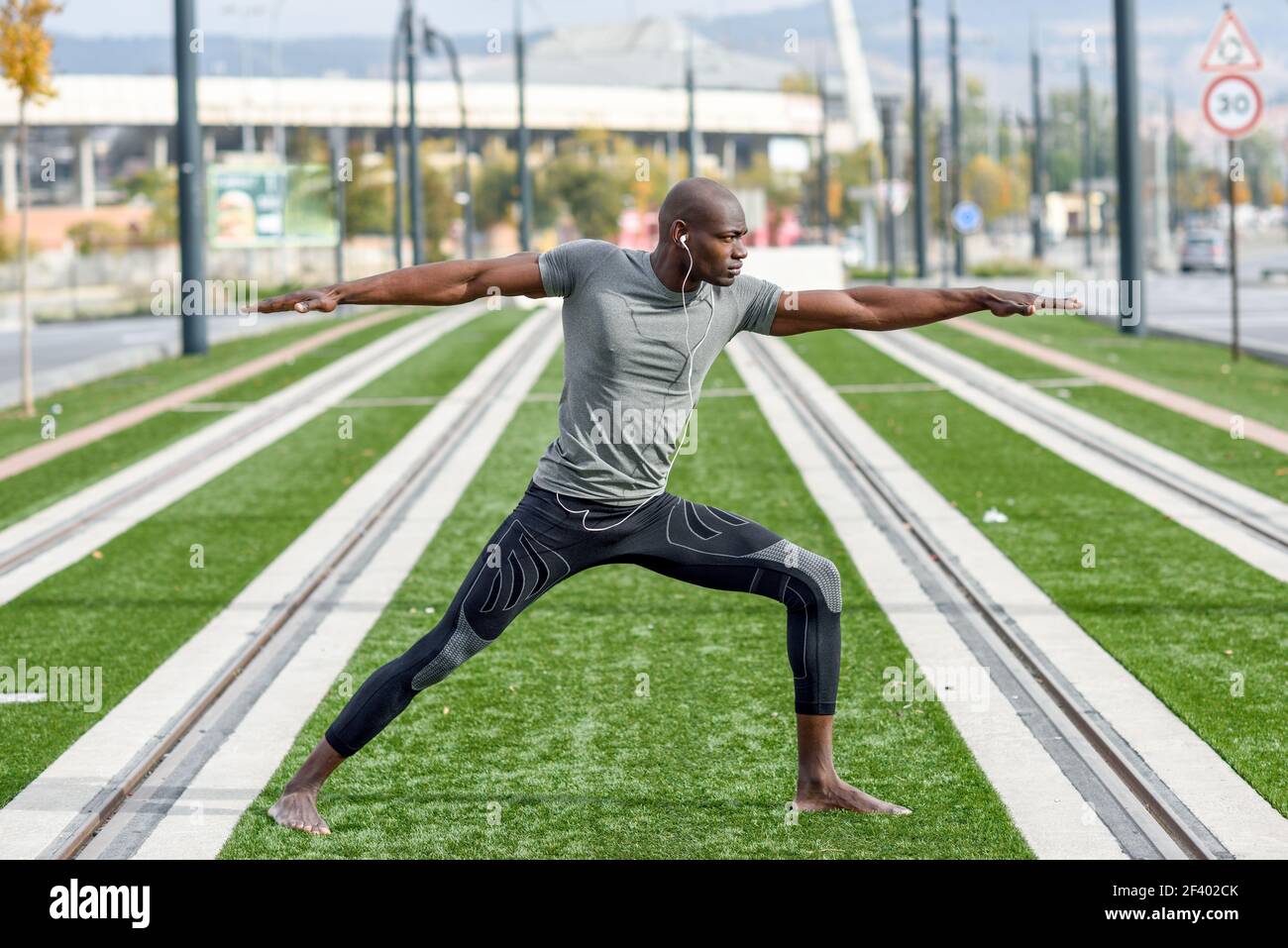 Uomo nero che pratica yoga in ambiente urbano. Uomo nero che pratica yoga in ambiente urbano. Un maschio africano che fa allenamento all'aperto. Foto Stock