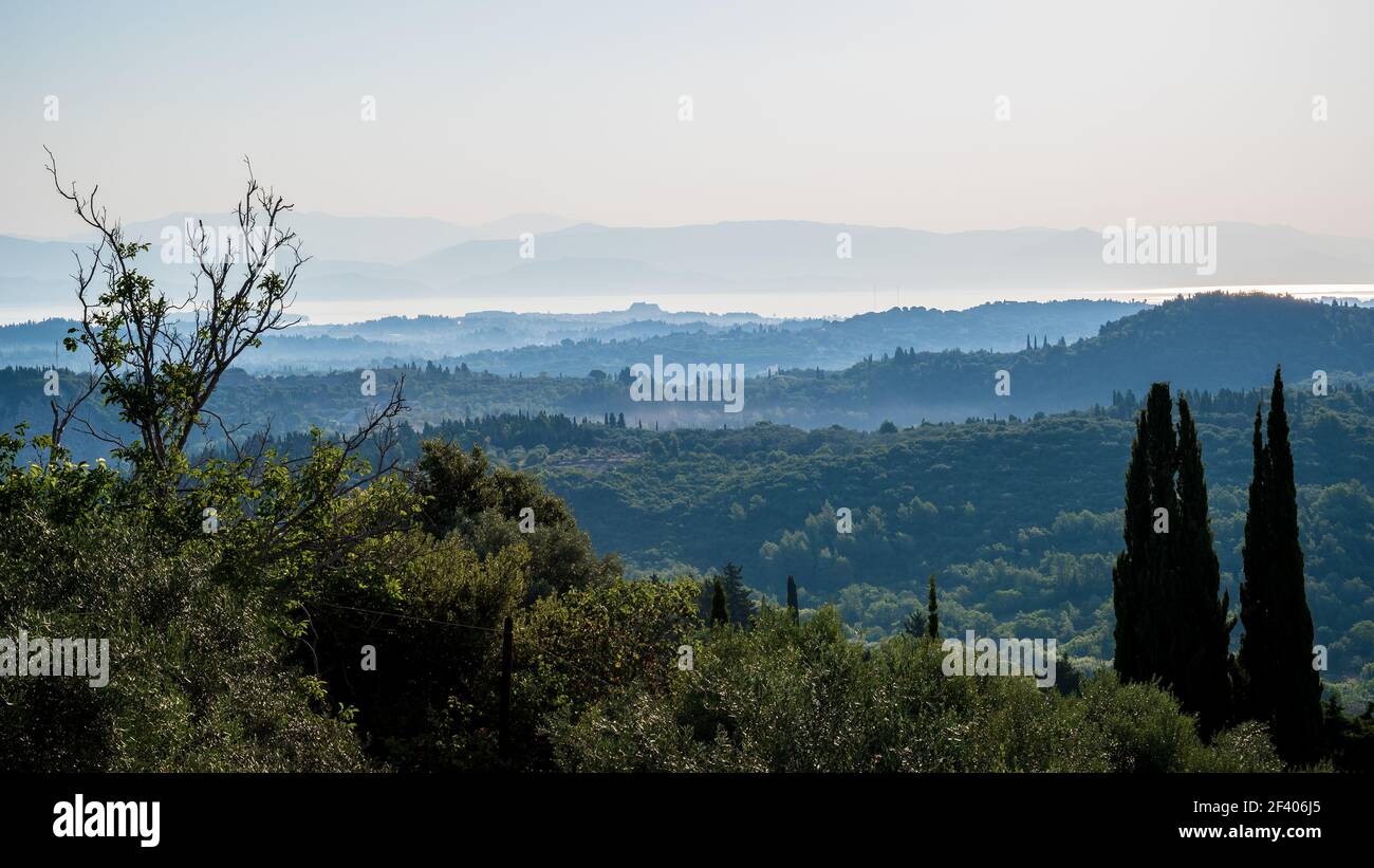 Vista sul paesaggio di Corfù, con vista sulle colline boscose fino al mare, al mattino presto Foto Stock
