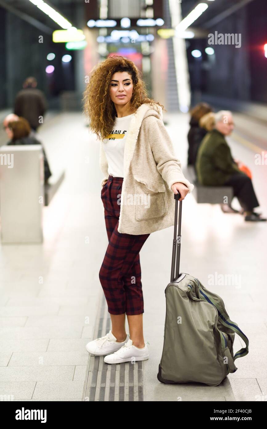 Bellissima giovane turista arabo in attesa il suo treno in una stazione della metropolitana. Ragazza araba in abiti casual. Foto Stock