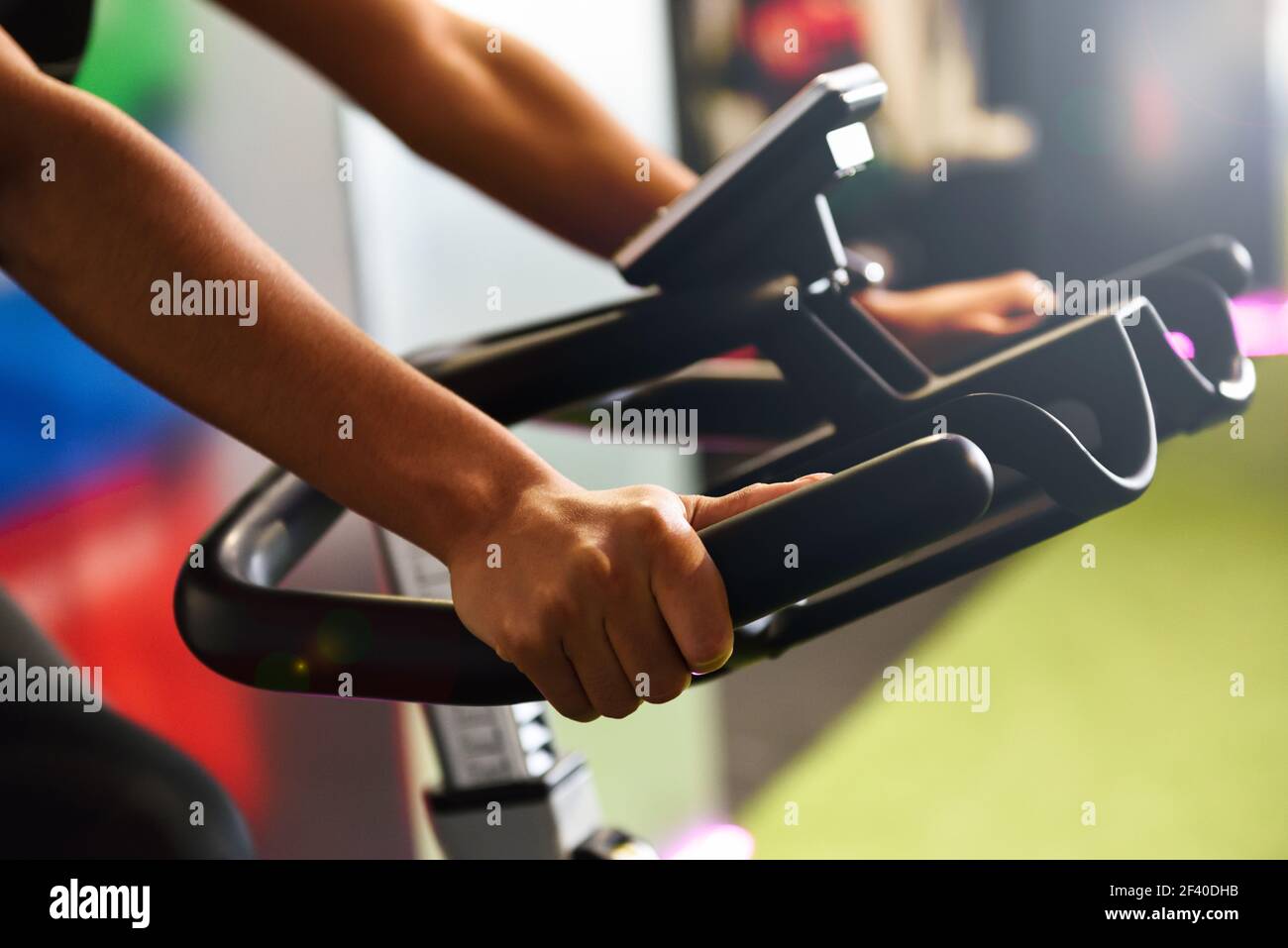 Primo piano di allenamento delle mani della donna in una palestra che fa filatura o ciclo indoor. Concetto di sport e fitness. Foto Stock